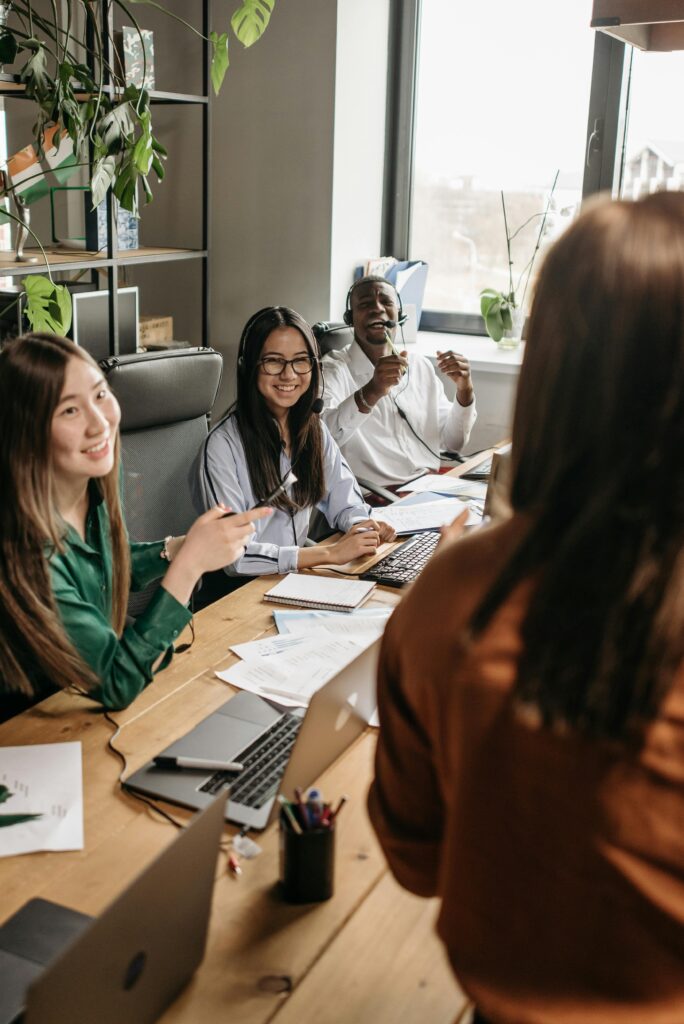 A diverse group of young professionals collaborating around a table in a modern office setting.