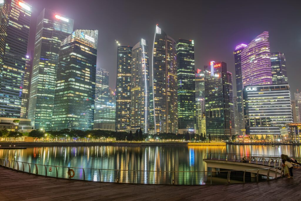 Regional Investment Portfolio Vibrant night view of Singapore's Marina Bay skyline reflecting on the waterfront.